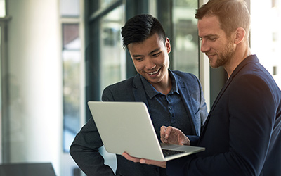 Two IT professionals reviewing some information on a laptop